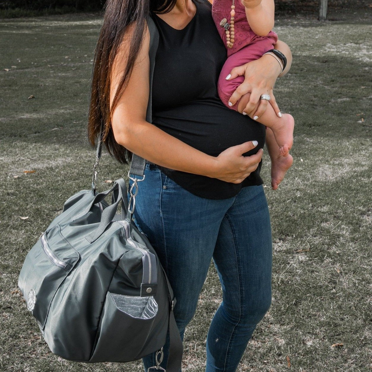 alt="pregnant mum wearing The DUFFLE Nappy Bag crossbody strap"
